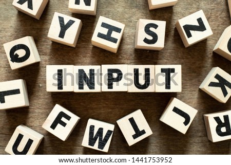 Letter block in word input with another block on wood background Royalty-Free Stock Photo #1441753952
