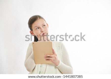 Portrait of a cute little kid with smart phones and tablet over white background. Happiness teenage girl.