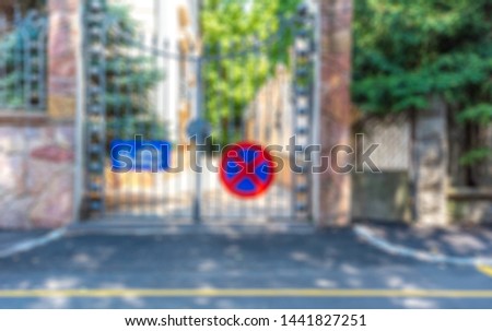 Blurred image of private house estate entrance with no parking sign and truck towing sign on house gate background backdrop horizontal blur shot out of focus
