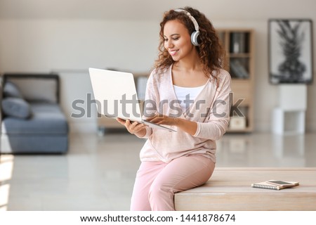 Young African-American student listening to music while preparing for exam