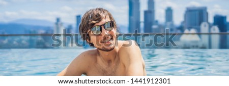Man relax in swimming pool in sunrise, on rooftop in the city. Rich people BANNER, LONG FORMAT