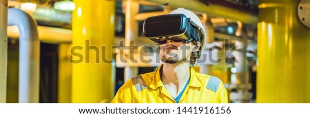 BANNER, LONG FORMAT Young woman in a yellow work uniform, glasses and helmet uses virtual reality glasses in industrial environment, oil Platform or liquefied gas plant