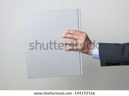 man in a suit holding a book, side view