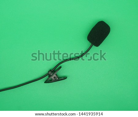 Portable Mini 3.5mm Tie Lapel Lavalier Clip Microphone on green screen, top view image.         