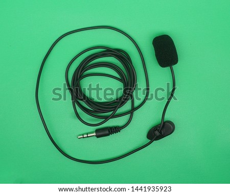 Portable Mini 3.5mm Tie Lapel Lavalier Clip Microphone on green screen, top view image.