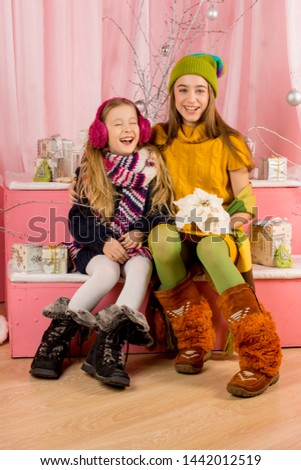 Sisters in new year. holiday of Christmas. Joy. Pink background. Portrait. Teenager.