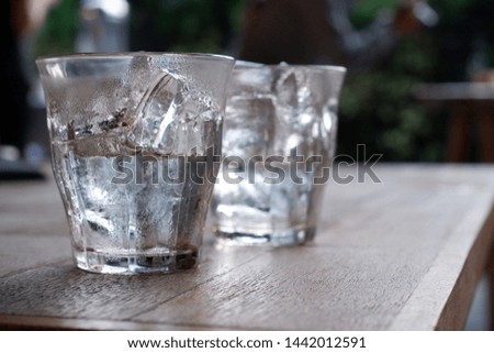 Two glasses of ice, some has melted