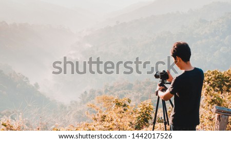 web banner and panorama of earth day and environment care travel concept from photographer man during take photo beautiful landscape of tropical forest with haze and soft focus of layer mountain 