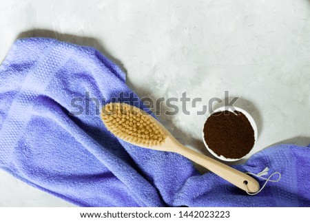 Wooden brush for dry massage and ground coffee with a towel.