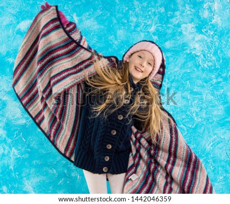 Girl dancing with snow. holiday of Christmas. Joy. Blue background. Portrait.