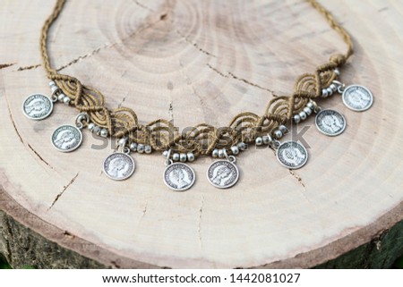 Macrame summer jewelry with brass metal components on wooden background
