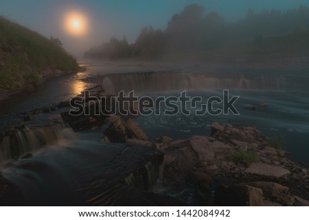 Waterfall under a fool moon with fog