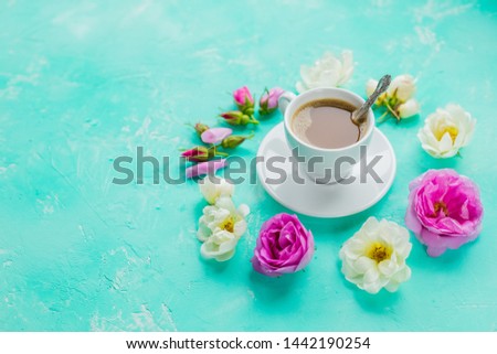 white cup of coffee and fresh beautiful pink and white roses flowers , flat layout, copy space.Coffee drink concept with cup of americano and roses on concrete background.Good Morning