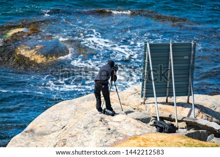 Photographer capture ongoing event on the beautiful coastline of Sweden - Swedish Archipelago photo camera course on sunny day.
