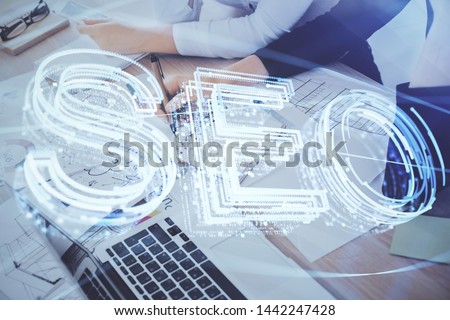 Double exposure of woman's hands making notes with SEO icon. Concept of Search engine optimization