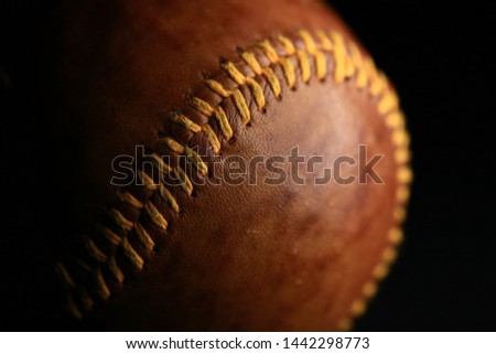 Vintage brown leather baseball on a black background.