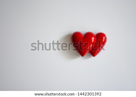 Two heart magnets on a fridge