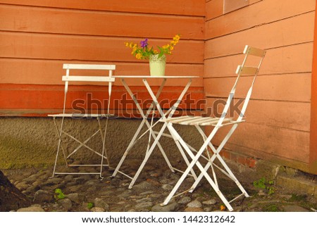 white table and outdoor chairs in an outdoor cafe