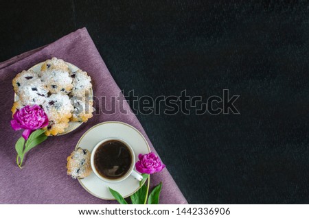 coffee with a cupcake and flowers. good morning! blueberry muffins and americano on a purple and black background. Espresso with baking. pink peonies in a stylish decor. copy space