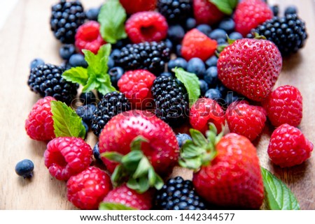 Strawberry, blueberry, raspberry variety on wooden and white background