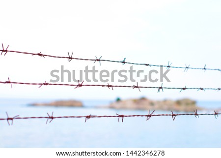 barbed wires and the sea in the background