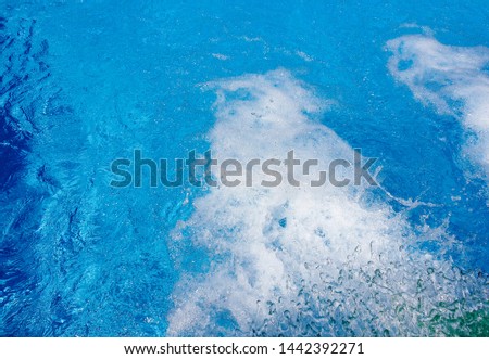 Pulsating blue pool water with jets of incoming water 