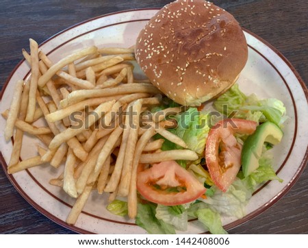 Plate with hamburger, french fries and salad.