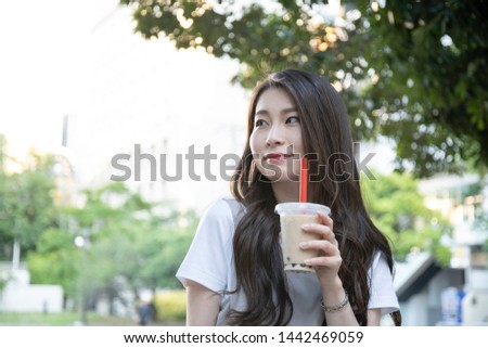 Woman drinking tapioca drink in park