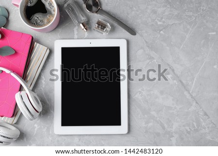 Flat lay composition with tablet on grey background, space for text. Blogger's workplace