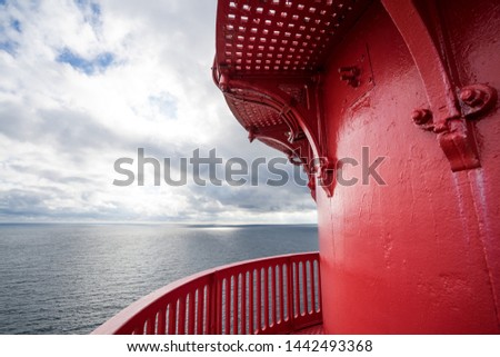 Red top of the Lindesnes Lighthouse (Lindesnes fyr). Coastal beacon at the southernmost tip of Norway. It is situated atop of the rock and supports marine navigation in the entrance of Skagerrak.