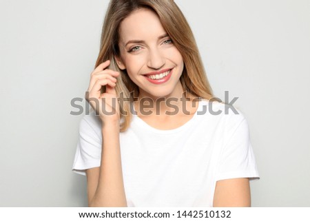 Portrait of young woman with beautiful face on grey background