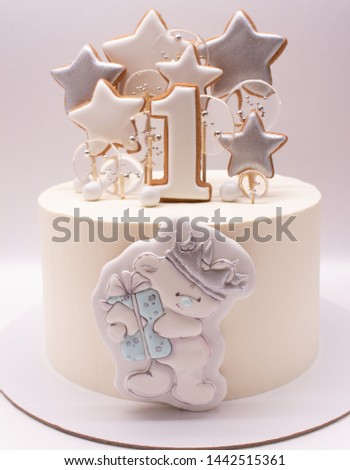 Delicious pinkBright cake with gingerbread in the form of a bear, stars and the number 1. On a white background.
