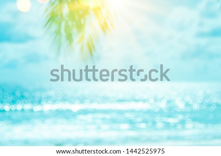 Blur beautiful nature green palm leaf on tropical beach with bokeh sun light wave abstract background. Copy space of summer vacation and business travel concept. Vintage tone filter effect color style