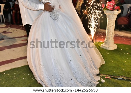 bride in white dress and groom dancing at night on the green grass with fireworks in the background, holiday, wedding