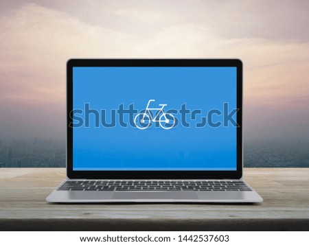 Bicycle flat icon with modern laptop computer on wooden table over office city tower and skyscraper at sunset sky, vintage style, Business bicycle shop online concept
