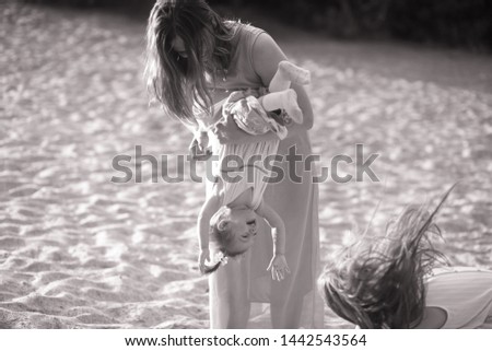 Mother has fun and plays with her little daughter on the walk. Black and white image.