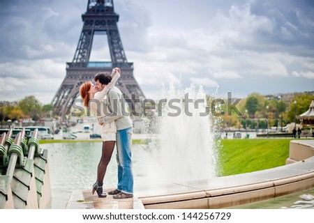 Lovers kissing in Paris with the Eiffel Tower in the Background
