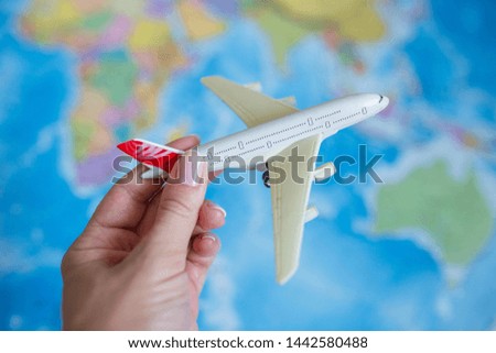 The model plane in a women hand on the background of the map. travel, tourism, air travel