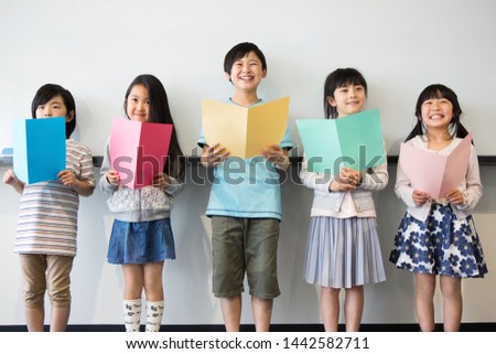 Primary school students who take music class Royalty-Free Stock Photo #1442582711