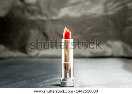 A red lipstick on the black and white background. Close up photo.