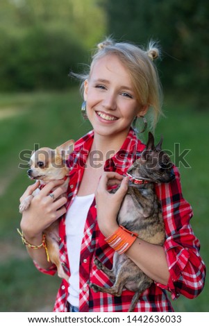 Young girl in a red shirt. The girl with the dogs. Walk with animals in the fresh air