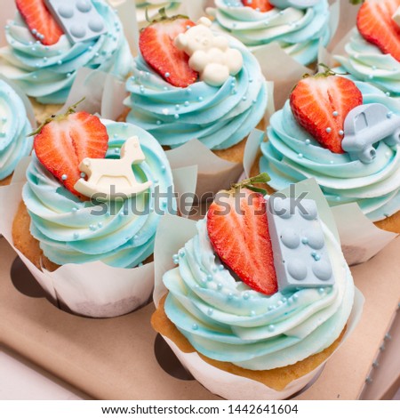 Colored cupcakes in the box. Decorated with berries