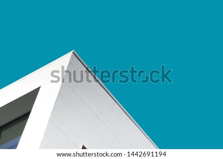 Abstract architecture with minimal aesthetics. White building detail against blue sky. High resolution architectural photography.
