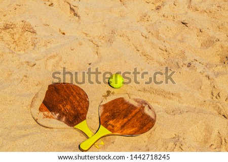 wooden beach rackets on the beach sand Royalty-Free Stock Photo #1442718245