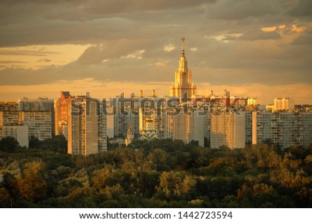 The tower of Moscow State University and Andrey Rublev modern church surrounded by residential houses in Ramenki district, sunset, of Moscow.