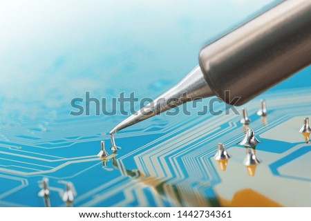 Soldering of electronic circuit board with electronic components. Soldering station. Engineers repair circuit board with soldering iron. Royalty-Free Stock Photo #1442734361