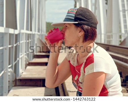 girl drinking from a cup in nature