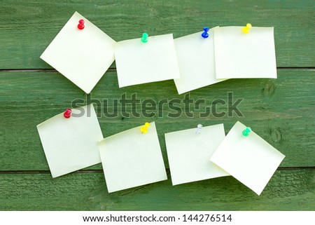 Green wooden wall with empty memo sticks
