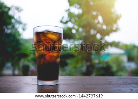 glass of cola with ice on table.