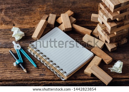 block wooden game with note book on wooden background
